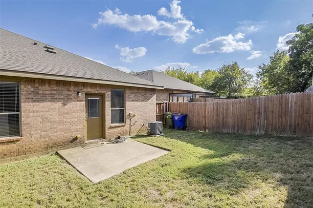 a view of backyard with barbeque grill and wooden fence
