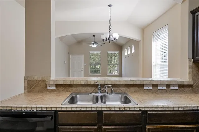 a kitchen with granite countertop a sink stove and cabinets