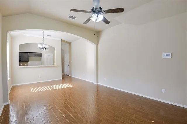 a view of a livingroom with wooden floor and a ceiling fan