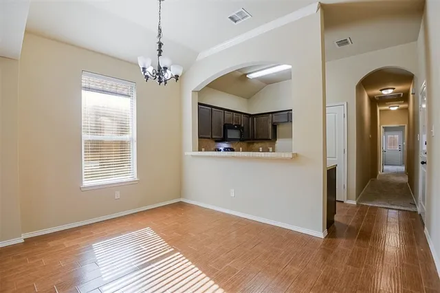 a view of a room with wooden floor and chandelier