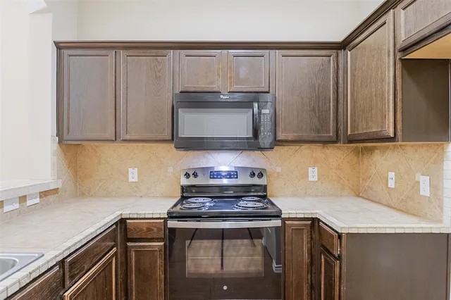 a kitchen with a sink stove and microwave
