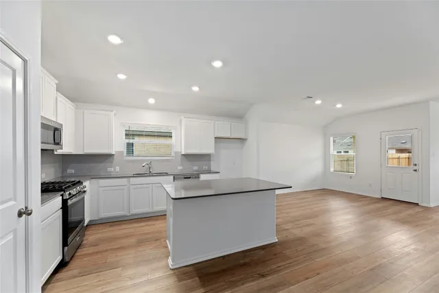 a kitchen with stainless steel appliances granite countertop a sink stove and refrigerator