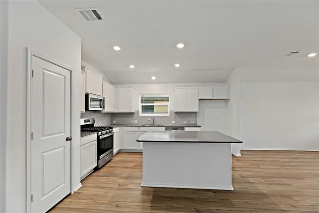 a kitchen with stainless steel appliances granite countertop a sink stove and refrigerator
