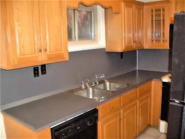 a kitchen with a sink cabinets and a window