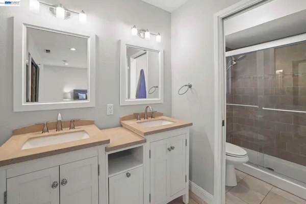 a bathroom with a granite countertop sink a toilet and a mirror