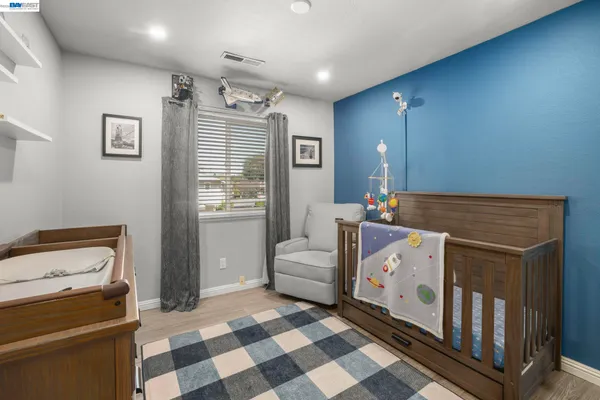 a living room with a baby crib furniture and a window