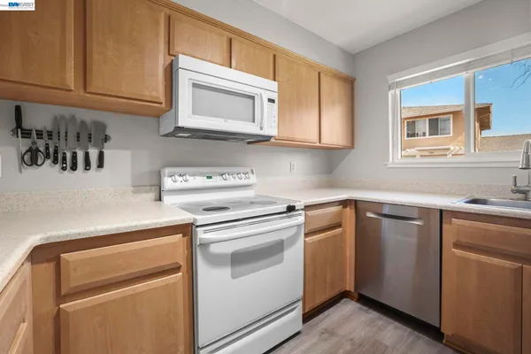 a kitchen with white cabinets and white appliances