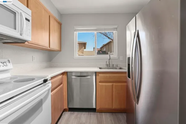 a kitchen with stainless steel appliances granite countertop a refrigerator and a sink