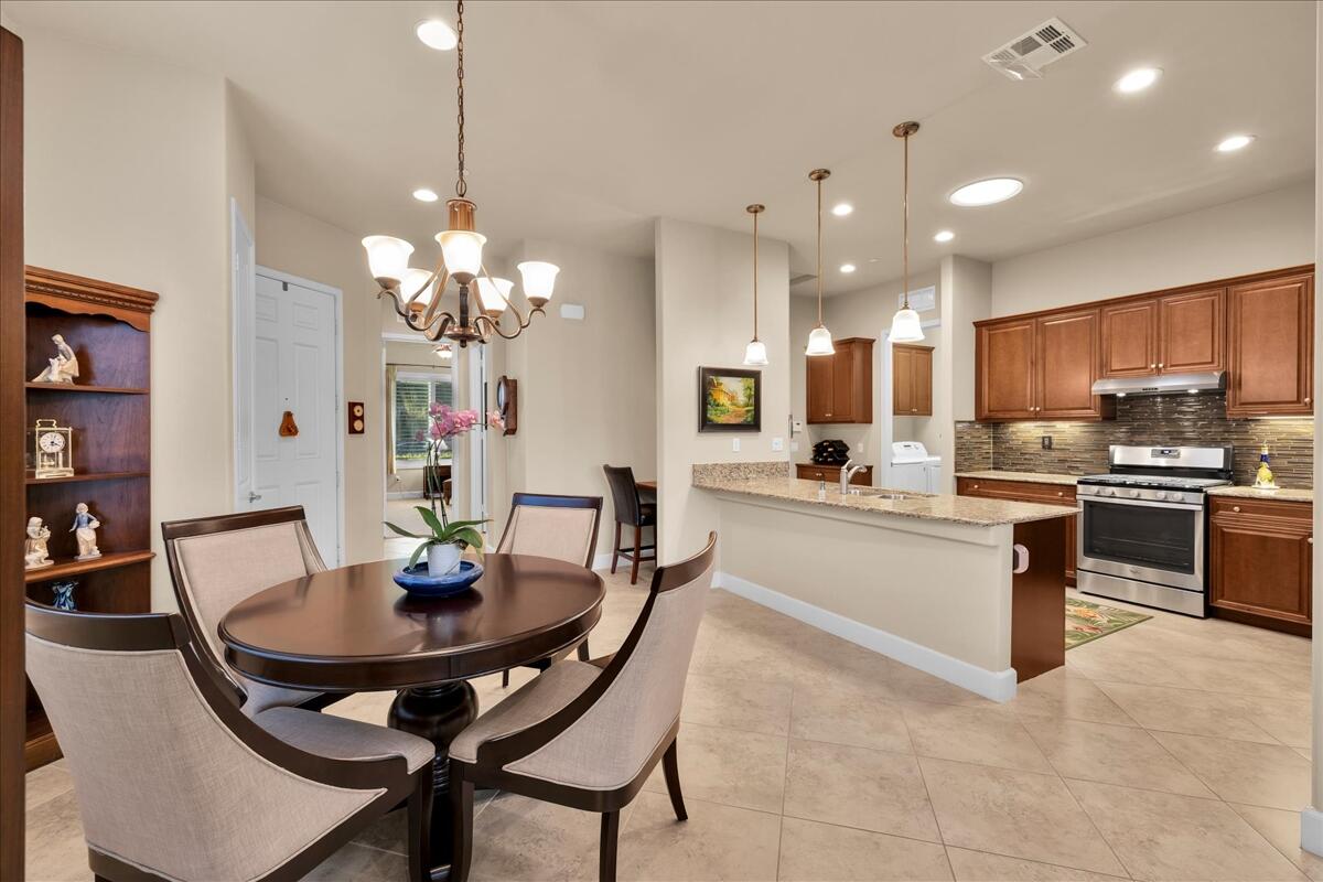 39048 Camino Orquesta Indio, CA 92203 - Photo 10 of 62 a kitchen with a dining table chairs and microwave