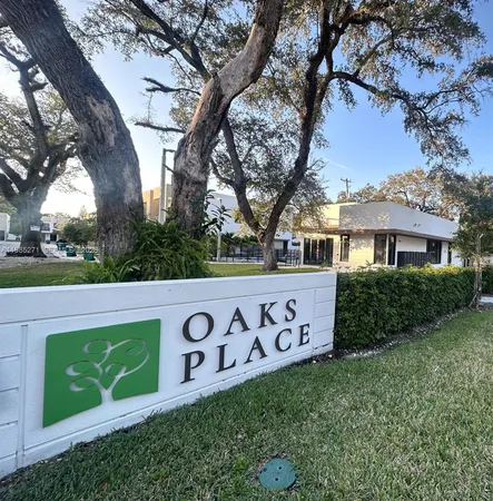 a view of a street sign under a large tree