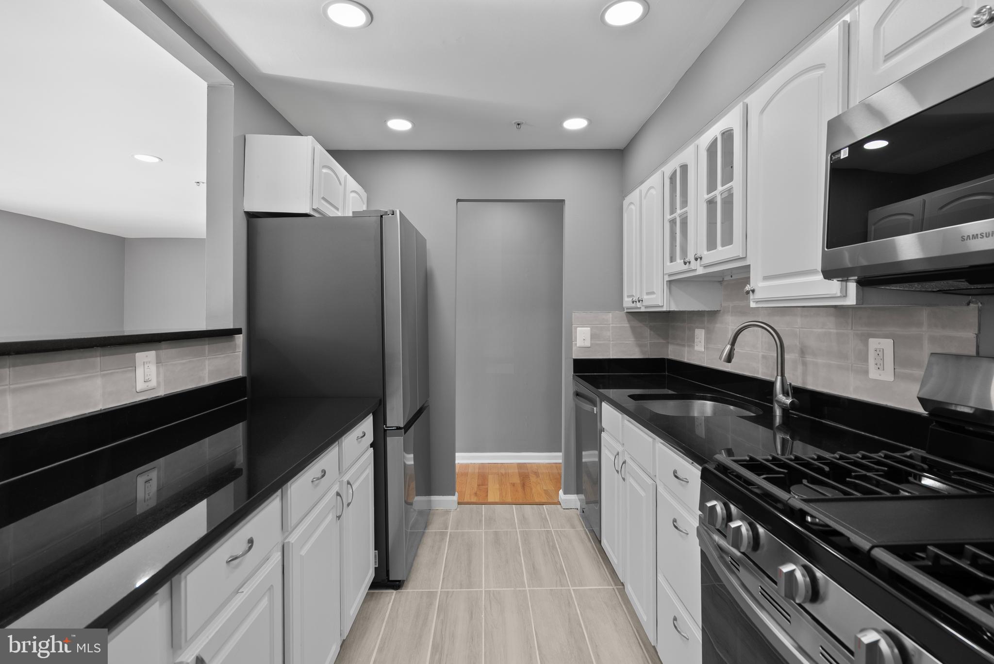 542 Wilson Bridge Drive, Unit 6743 B2 Oxon Hill, MD 20745 - Photo 10 of 27 a kitchen with granite countertop a refrigerator and a stove top oven