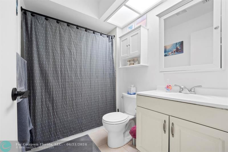 1088 Raintree Drive Palm Beach Gardens, FL 33410 - Photo 19 of 36 a bathroom with a toilet sink vanity and mirror