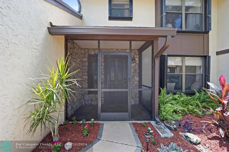 1088 Raintree Drive Palm Beach Gardens, FL 33410 - Photo 2 of 36 a potted plant sitting in front of a house