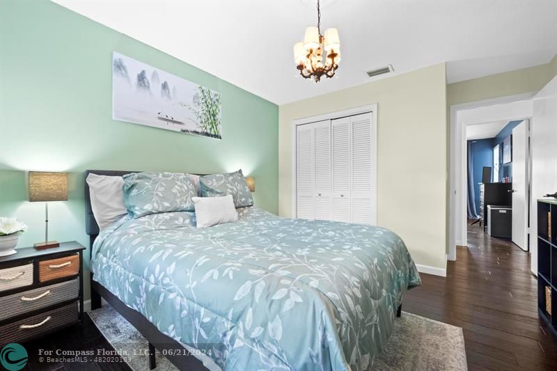 1088 Raintree Drive Palm Beach Gardens, FL 33410 - Photo 28 of 36 a bedroom with bed and wooden floor