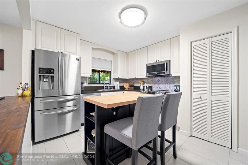 1088 Raintree Drive Palm Beach Gardens, FL 33410 - Photo 8 of 36 a kitchen with stainless steel appliances granite countertop a refrigerator a stove a sink and a microwave