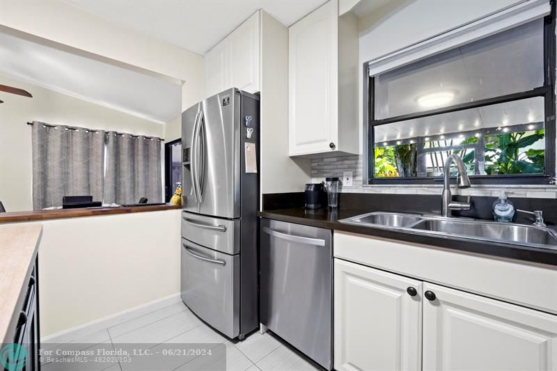 1088 Raintree Drive Palm Beach Gardens, FL 33410 - Photo 10 of 36 a kitchen with a refrigerator sink and stove