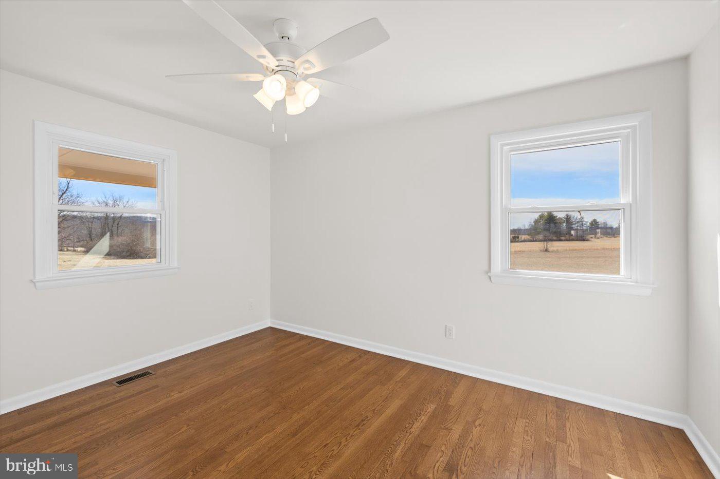 297 Tiger Valley Road Washington, VA 22747 - Photo 18 of 39 a view of an empty room with wooden floor and a window
