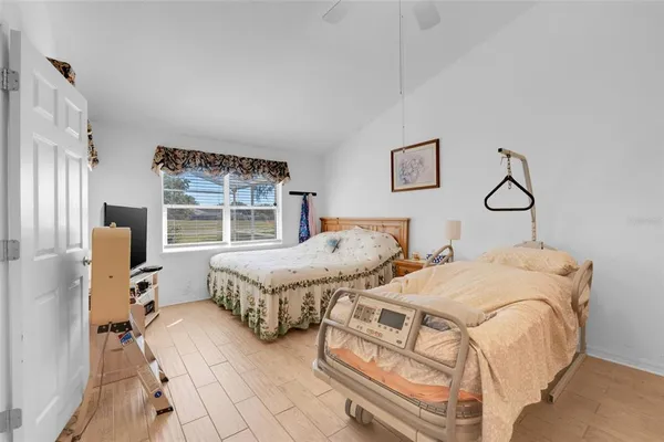 a view of a hallway with wooden floor and a bathroom