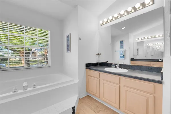 a bathroom with a granite countertop sink a mirror and a shower