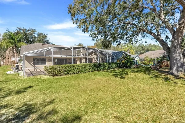 a view of a house with a big yard potted plants and large tree