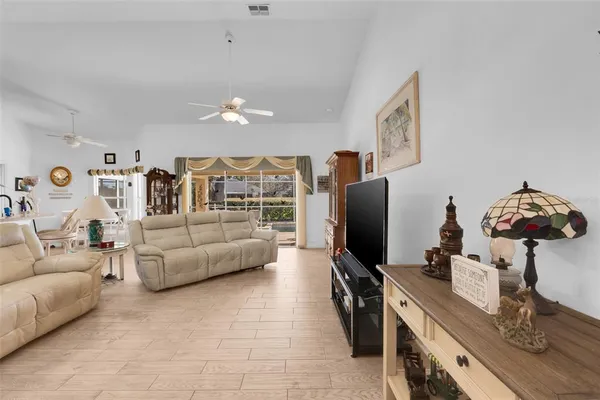 a living room with furniture and view of kitchen