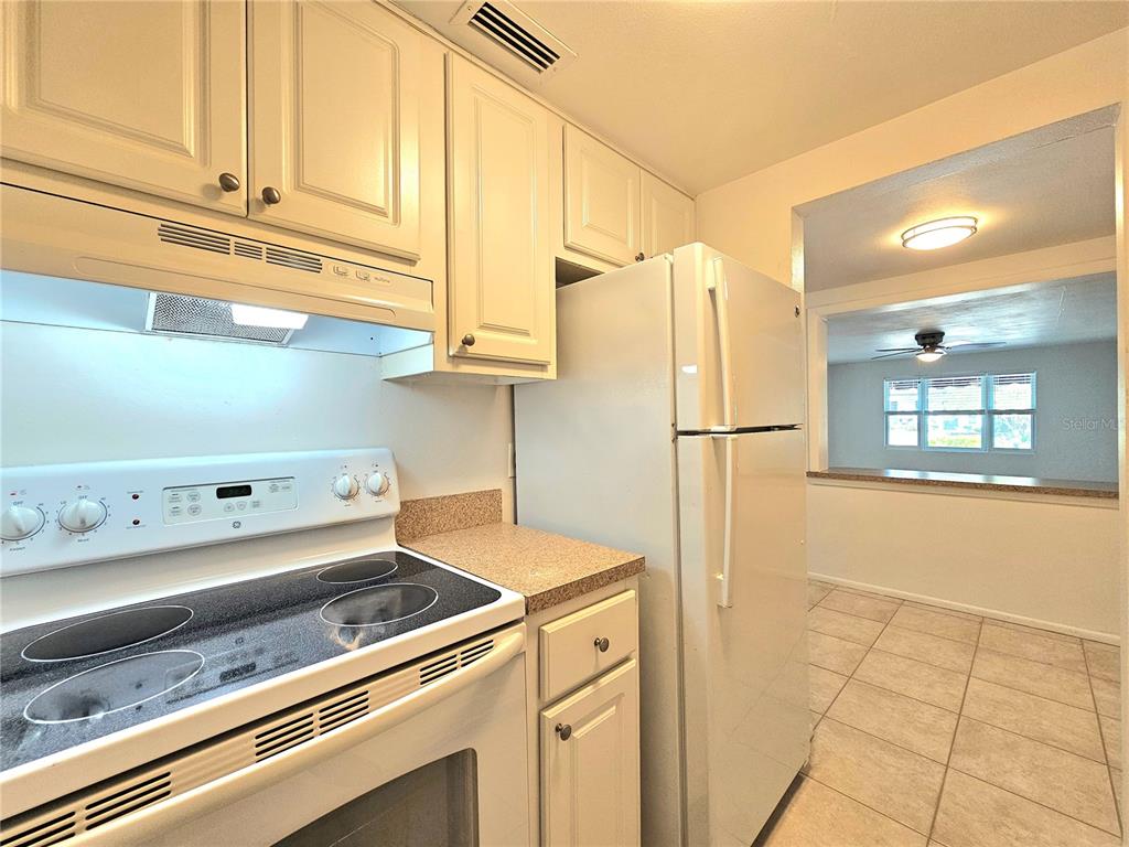 611 Lyndhurst Street Dunedin, FL 34698 - Photo 13 of 62 a kitchen with stainless steel appliances granite countertop a refrigerator and a stove