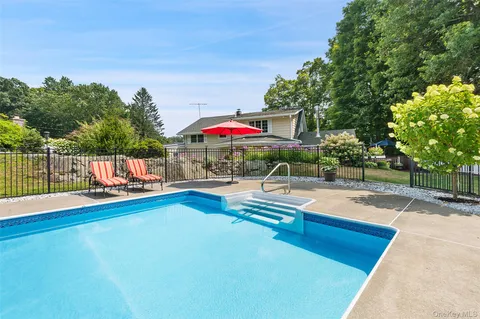 an outdoor space with swimming pool and furniture