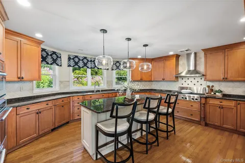 a kitchen with stainless steel appliances granite countertop wooden floor window and cabinets
