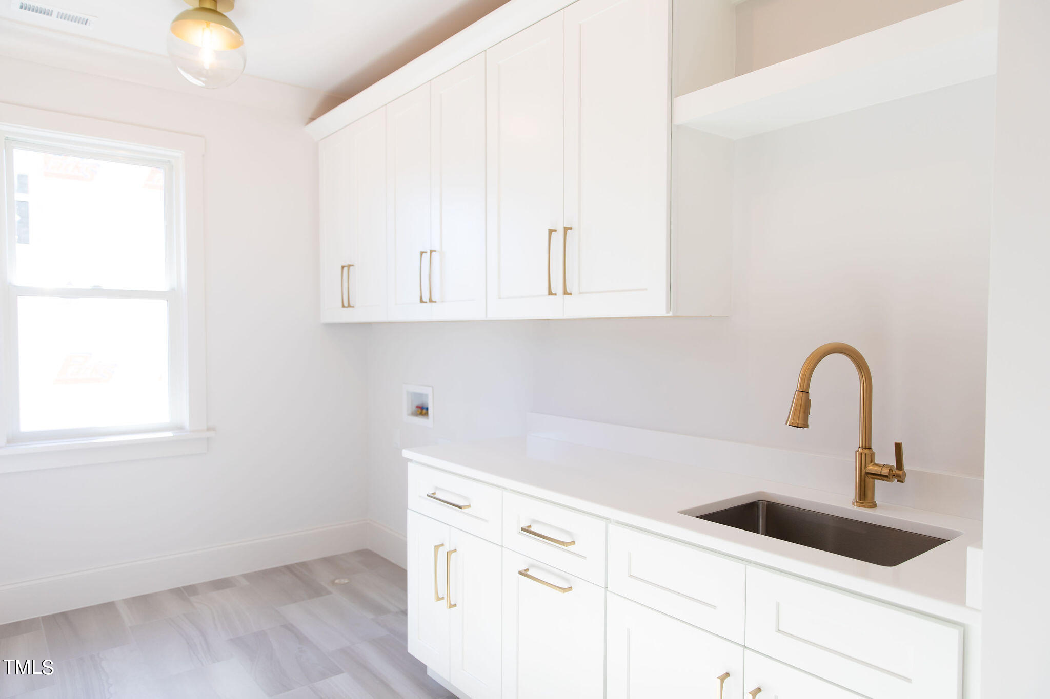 9412 Rawson Avenue Raleigh, NC 27613 - Photo 44 of 53 a kitchen with white cabinets and a sink