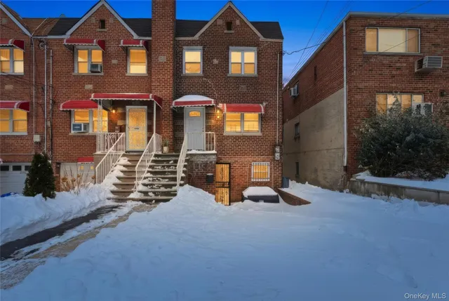 a view of a brick house with large windows and a yard