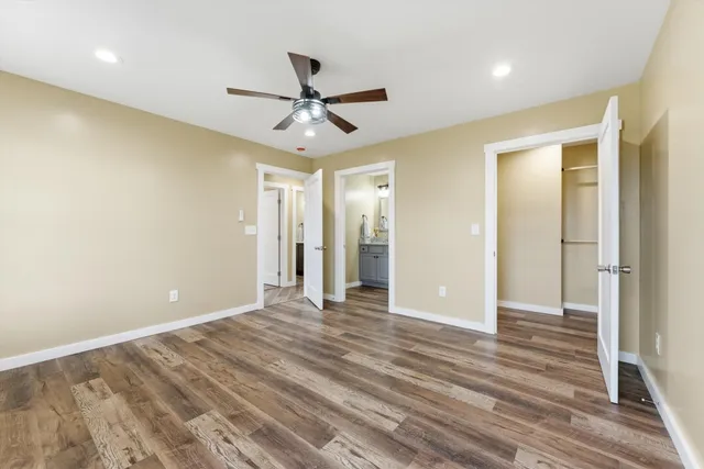 a view of a big room with wooden floor and a ceiling fan