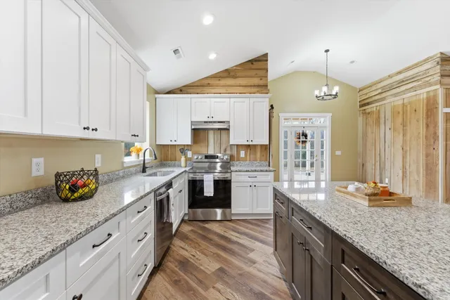 a kitchen with granite countertop a sink counter top space and cabinets