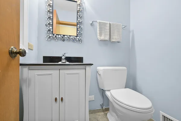 a bathroom with a granite countertop toilet and a sink