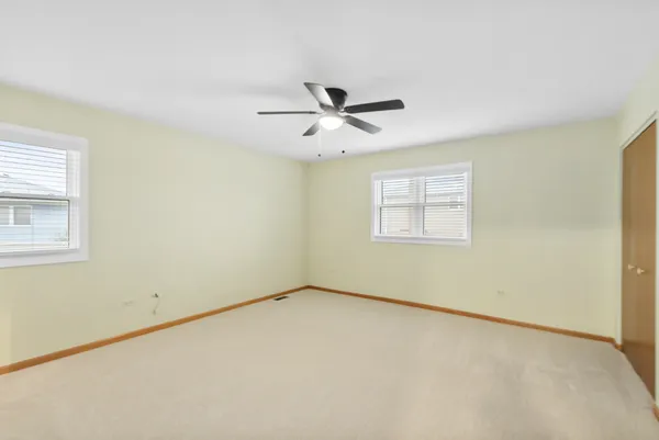 an empty room with a window and a fan
