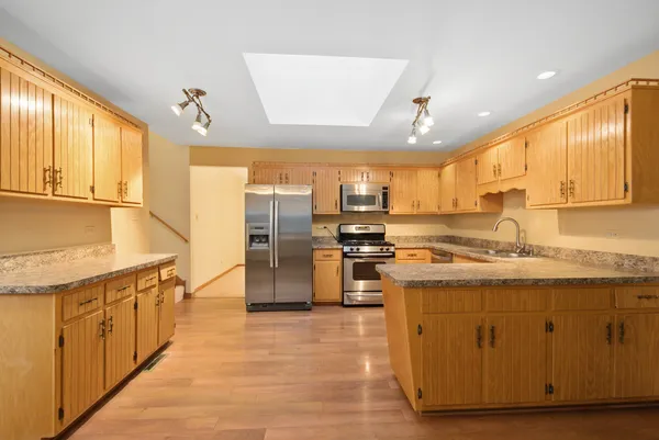 a kitchen with stainless steel appliances granite countertop a stove a sink and a refrigerator