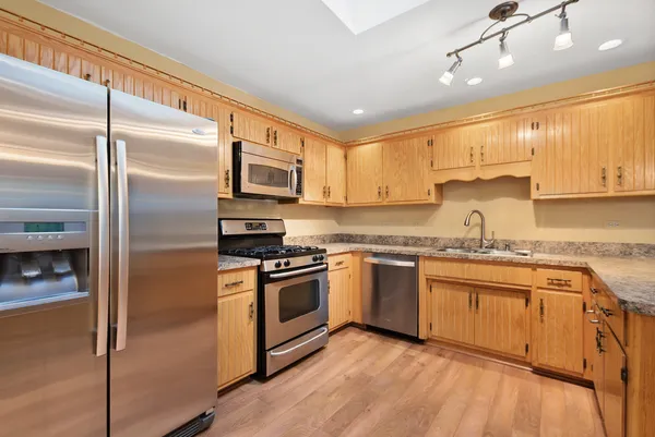 a kitchen with granite countertop stainless steel appliances and wooden cabinets