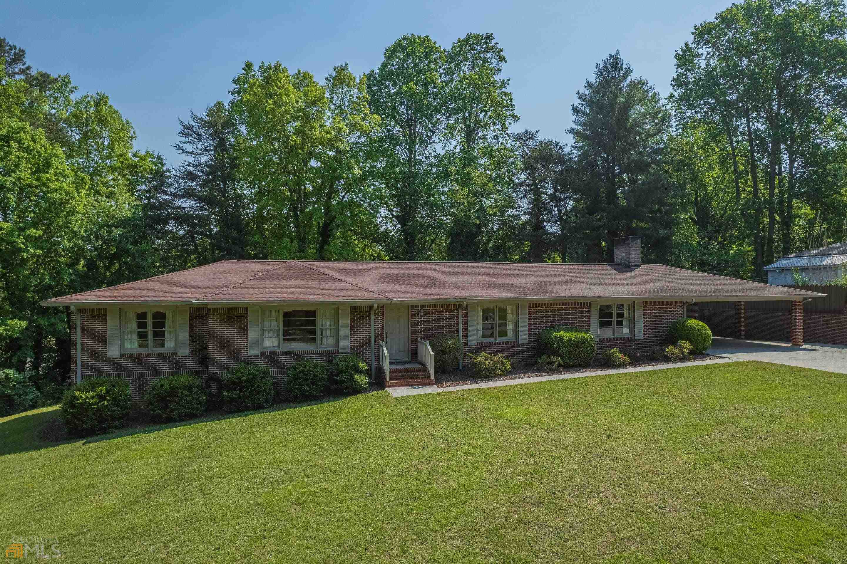 a front view of a house with a yard and trees