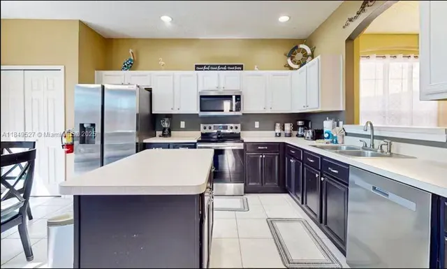 a kitchen with a sink a counter top space cabinets and stainless steel appliances