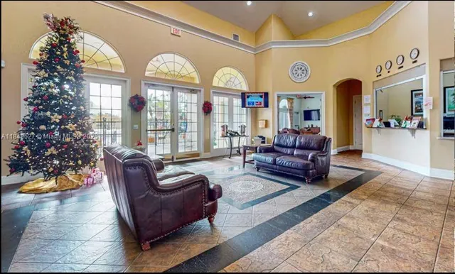 a living room with furniture a clock and a large window