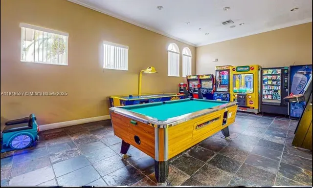 a room with pool table and windows