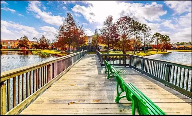 a view of swimming pool with outdoor seating and trees in the background