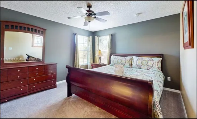 a bedroom with a bed and a mirror on dresser