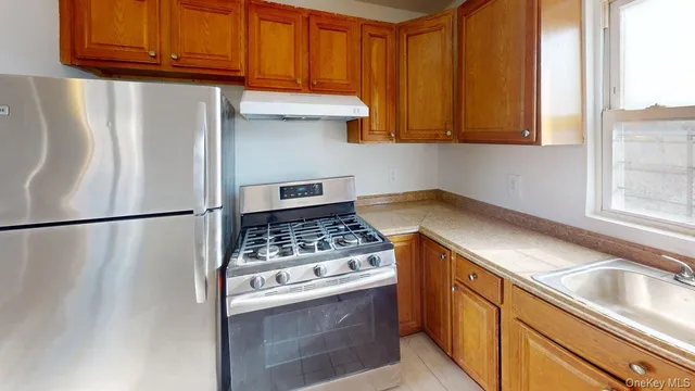 a kitchen with stainless steel appliances granite countertop a refrigerator and a stove