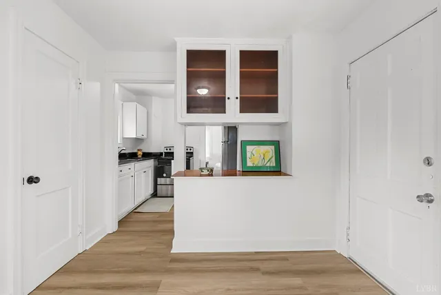 a living room with stainless steel appliances kitchen island granite countertop a refrigerator and a stove top oven