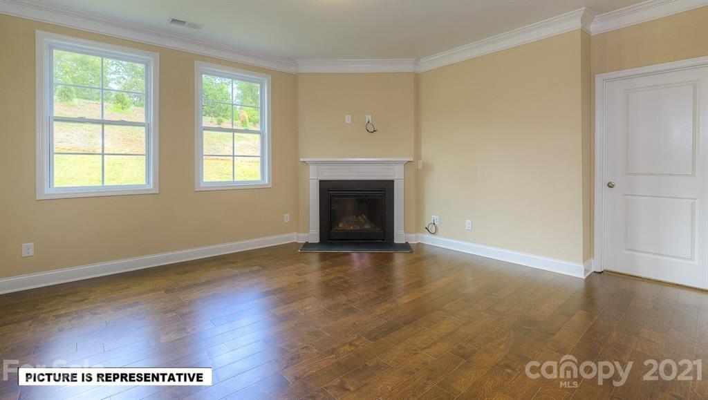 4366 Riverton Loop Denver, NC 28037 - Photo 7 of 14 an empty room with wooden floor fireplace and windows