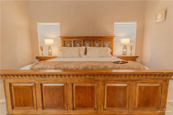 a bedroom with a bed lamp and a large window