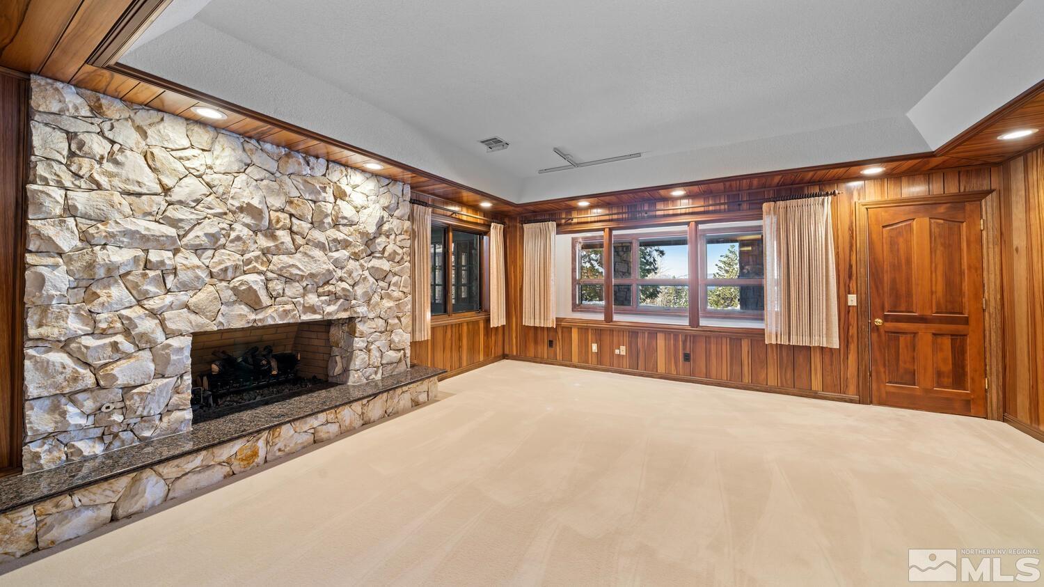 202 Pine Tree Lane Glenbrook, NV 89413 - Photo 12 of 40 a spacious bedroom with a balcony a bed and a fireplace