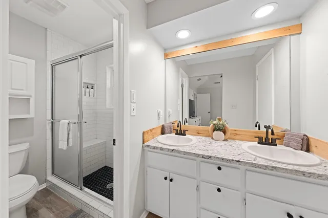 a bathroom with a granite countertop sink toilet and shower