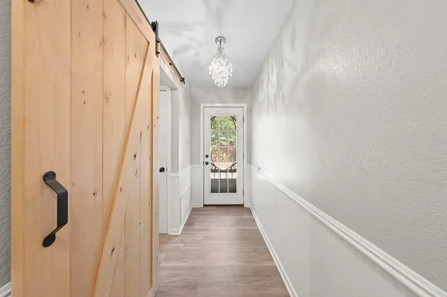 a view of a hallway with wooden floor and staircase