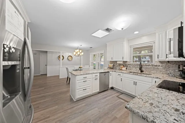 a kitchen with granite countertop a sink appliances cabinets and furniture